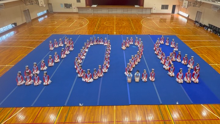 体育館のマット上で「2026」の人文字をつくるMARINEメンバー